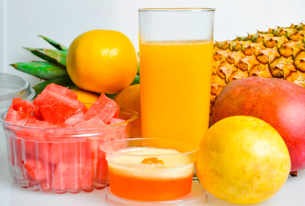 jugo de naranja rodeada de frutas ricas en vitamina c
