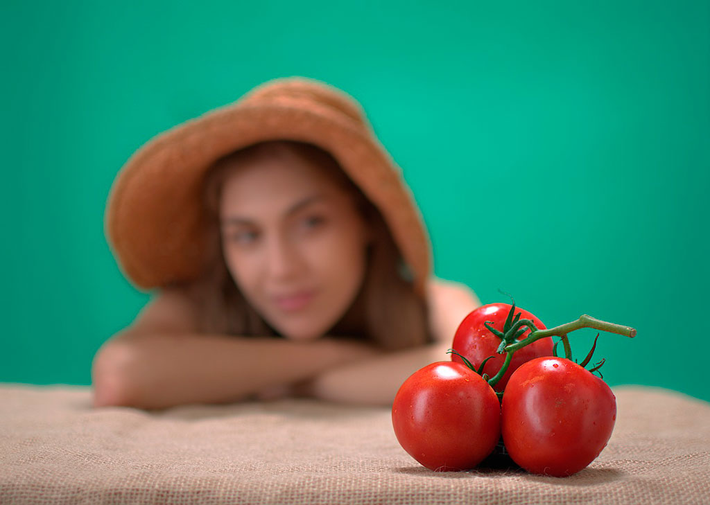 mujer mirando a unos tomates rojos frescos