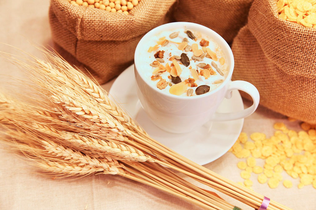 taza de avena con hojuelas encima de una mesa de madera